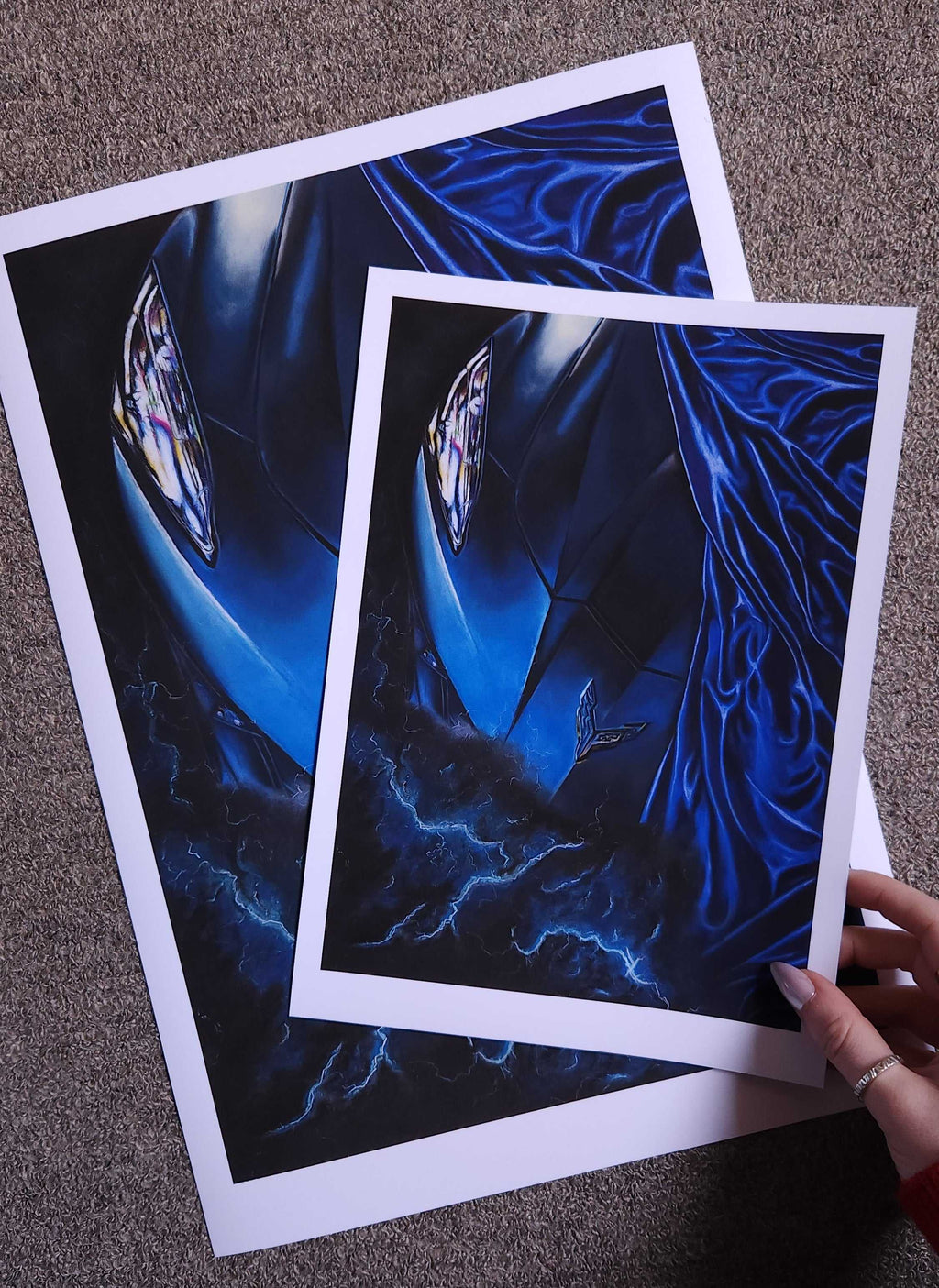Two blue abstract art prints on a textured surface