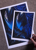 Two blue abstract art prints on a textured surface
